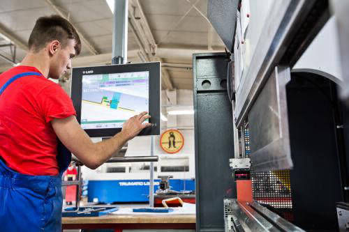 szakember épp beállítja a Bear-Lock gyár egyik gépét